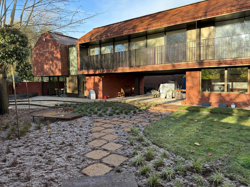 A completed garden in Marlow showcasing a harmonious blend of architecture and landscape — with Corten steel detailing, layered planting, and water-sensitive design that turns flood management into a defining aesthetic feature. Completed garden in Marlow featuring layered planting, Corten steel walkway and bridge over a seasonal pond, and permeable gravel paths -a sustainable landscape combining flood management with rustic elegance and contemporary design