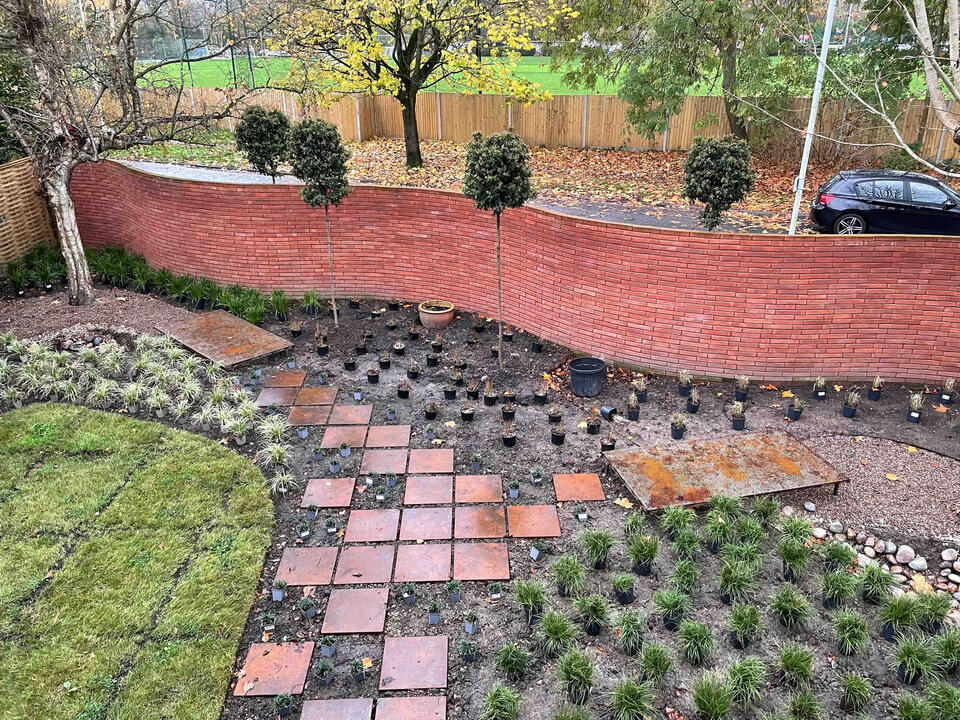 Layered planting and Corten steel detailing define the Marlow garden, blending soft textures with contemporary structure to create a resilient, low-maintenance landscape. View across the completed Marlow garden showing newly planted borders, Corten steel edging, and a patterned pathway — an example of modern eco garden design in Marlow.